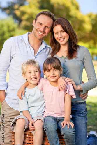 Photo: Smiling family picnicking in the park Smiling family picnicking in the park