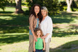 Smiling family looking at the camera in the park