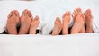 Feet of a family in a bed