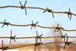 barbed wires against blue sky.