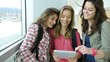 Teenagers using electronic tablet in school hall