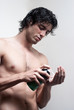 Photo: Portrait of a young handsome man with a skin for shaving Portrait of a young handsome man with a skin for shaving