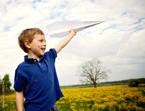 Photo: Boy Flying a Paper Airplane Boy Flying a Paper Airplane