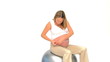 Pregnant woman measuring her waist against a white background