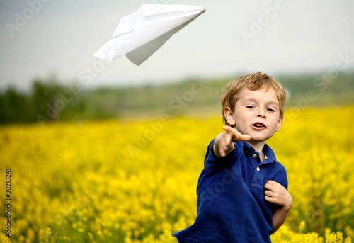 Photo: Boy Flying a Paper Airplane Boy Flying a Paper Airplane