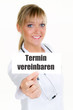 ärztin zeigt schild, termin vereinbaren