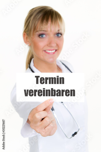 Photo: ärztin zeigt schild, termin vereinbaren ärztin zeigt schild, termin vereinbaren