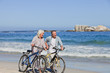 Retired couple with their bikes on the beach