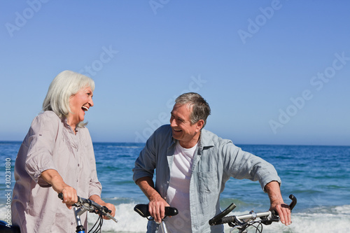Photo: Retired couple with their bikes on the beach Retired couple with their bikes on the beach