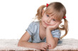 Thoughtful girl lying on the thick carpet