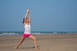 Young woman doing yoga on the beach