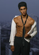 Man with necktie stands against sky scrapper.