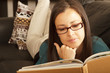 Brunette relaxing at home with book.