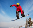 Snowboarder jumping through air with  blue sky in background