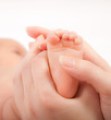 Mother's hands massaging little baby's foot