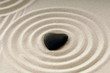 Stein als schwarzes Herz im Sand mit Spuren Stein als schwarzes Herz im Sand mit Spuren