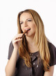 Pretty young woman eating chocolate