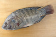 Raw fish called "tilapia" photographed on wood
