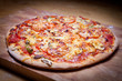 Foto: Holzofen Pizza auf Holzbrett - vignetiert Holzofen Pizza auf Holzbrett - vignetiert