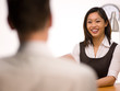 An asian woman giving her resume to a man at a job interview An asian woman giving her resume to a man at a job interview