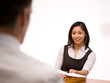 An asian woman giving her resume to a man at a job interview An asian woman giving her resume to a man at a job interview