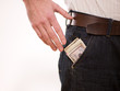A man putting american money in his pants pocket A man putting american money in his pants pocket