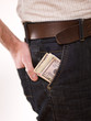 A man putting american money in his pants pocket A man putting american money in his pants pocket