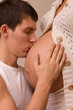 Man kisses belly of his pregnant wife