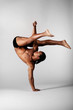 young male dancer posing over grey background young male dancer posing over grey background
