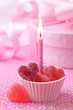 Pink candle with red heart candies