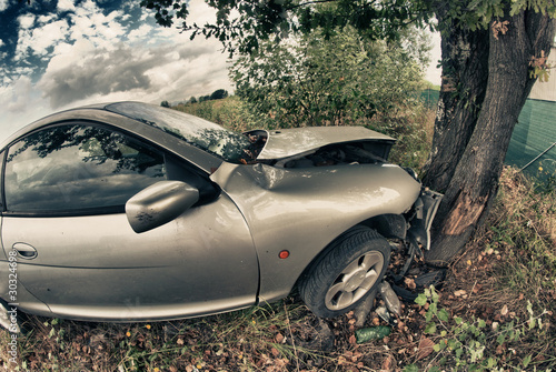 Photo: Broken Car After an Accident against a Tree Broken Car After an Accident against a Tree