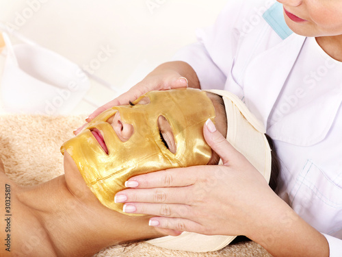 Photo: Girl with gold facial mask. Girl with gold facial mask.