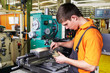 Foto: trainee with caliper rule standing in front of a rotary cutter trainee with caliper rule standing in front of a rotary cutter