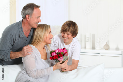 Photo: Son offering bunch flowers on mother's birthday Son offering bunch flowers on mother's birthday