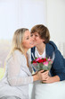 Photo: Son offering bunch flowers on mother's birthday Son offering bunch flowers on mother's birthday