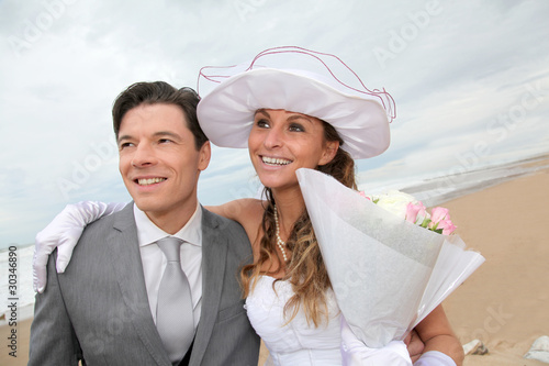 Photo: Portrait of happy married couple at the beach Portrait of happy married couple at the beach