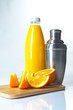 Orangenstücke mit Cocktailshaker auf weißem Hintergrund / Orange
