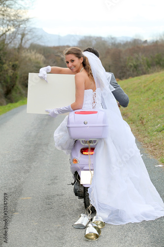 Photo: Bride on a motorcycle ride holding whiteboard Bride on a motorcycle ride holding whiteboard