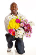 Young kneeling man with large bouquet of flowers