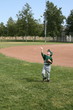 Boy in baseball uniform playing catch