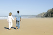 Photo: Young couple in love walking at the beach Young couple in love walking at the beach