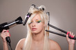 Young woman with hairdryer and hairbrushes