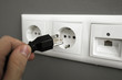 Hand inserting electrical US plug in European Socket. Hand inserting electrical US plug in European Socket.