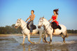 Man and a woman in love with the sea on horseback