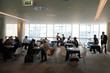 People sitting at discussion tables in meeting hall People sitting at discussion tables in meeting hall