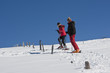 Skifahrer steigen Schneehang hoch