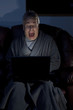 Man in housecoat working late series shocked computer crash