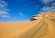 Side view of off all terrain motor car driving across sandy dese