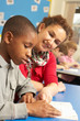Schoolboy Studying In Classroom With Teacher