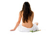 Beautiful young woman in towel sitting on the floor in white bac
